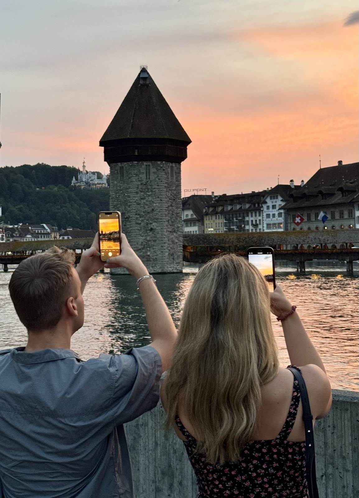 Zwei Personen fotografieren den Wasserturm in Luzern