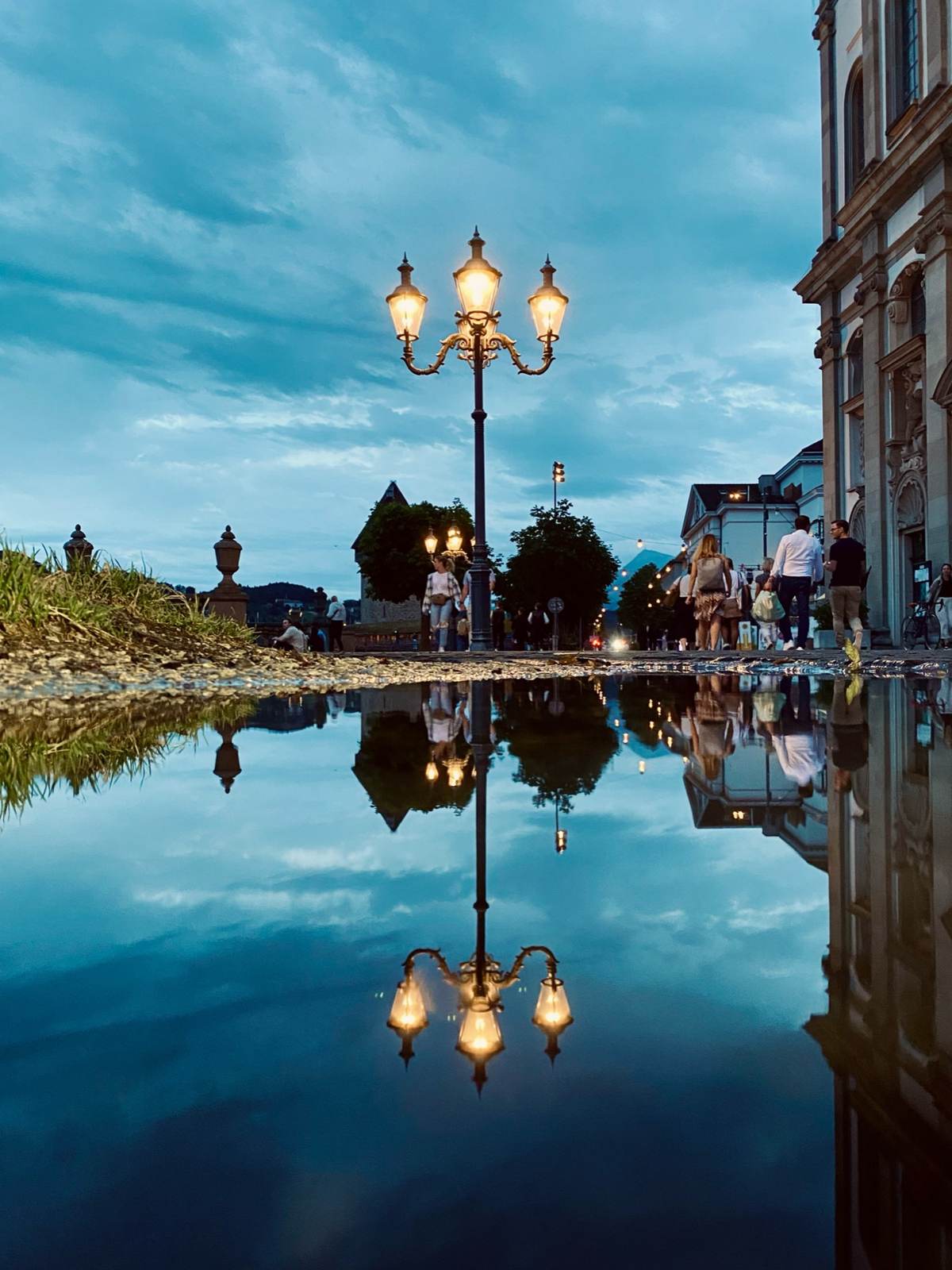 Strassenlaterne in Luzern, gespiegelt in einer Pfütze